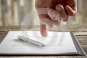 Man pointing to a document with a pen