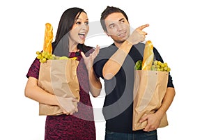 Man pointing to his amazed wife at shopping