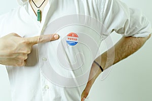 Man pointing to an I Voted Today sticker on his chest