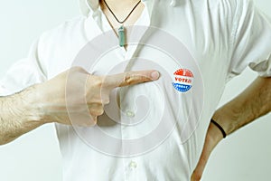 Man pointing to an I Voted Today sticker on his chest