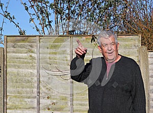 Man pointing upwards and looking towards camera.