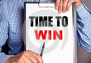 The man points with a pen to the phrase TIME TO WIN on a white sheet