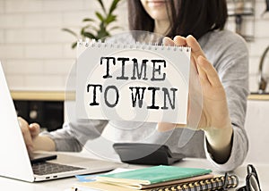 with a pen to the phrase TIME TO WIN on a white sheet