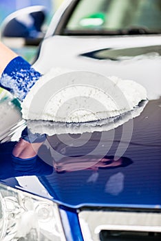 Man polishing the bonnet of his luxury car