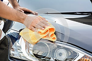 A man polishing car with microfiber cloth
