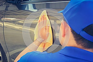 A man polishing car with microfiber cloth photo