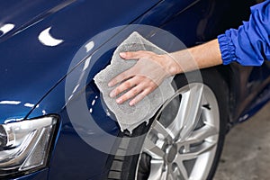 Man polishing cleaning car with microfiber cloth, detailing or valeting concept