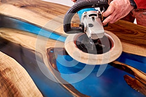 Man polishing epoxy table close up