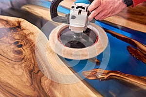 Man polishing epoxy table close up