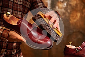 Man polishing leather shoes with brush.