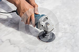 Man polishing marble table by angle grinder