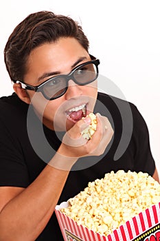 Man with popcorn bucket and 3D glasses