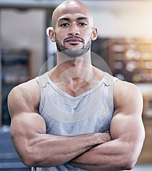 Man, portrait and arms crossed in gym with serious for training client, strong body and health career. Pride, muscle and