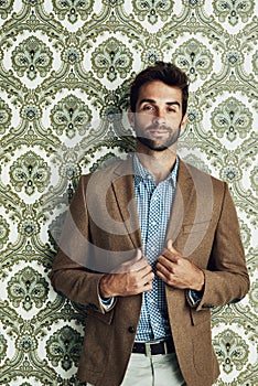 Man, portrait and fashion on wallpaper or stylish confidence with suit jacket with pattern background, classy or pride