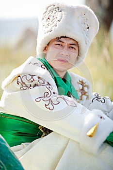 Man portrait on grass in traditional clothes looking at camera