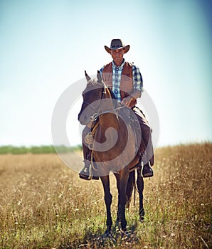 Man, portrait and horse riding in countryside as cowboy or adventure in Texas meadow for explore, exercise or training