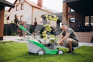 Man portrait mowing the lawn with lawnmower having problem