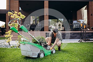 Man portrait mowing the lawn with lawnmower having problem