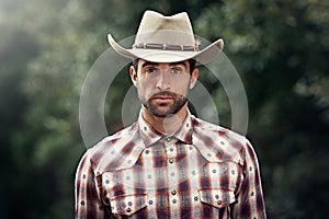 Man, portrait and outdoor cowboy clothes, western culture and countryside ranch in Texas. Male person, hat and flannel