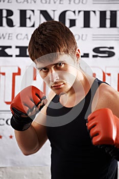 Man, portrait and professional fighter with boxing gloves in martial arts or MMA sports for self defense in dojo
