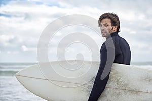 Man, portrait and surfer on beach for exercise, sport or waves on shore in outdoor fitness. Rear view of male person or