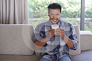 Man, portrait and tea to relax in home, smile and satisfaction with hot beverage on weekend. Male person, happy and