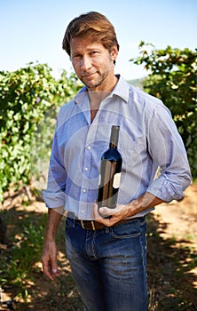 Man, portrait and vineyard with bottle of wine for quality control, agriculture and sustainable winery. Vintage, red