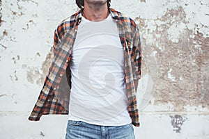 Man posing in blank white tshirt against street wal