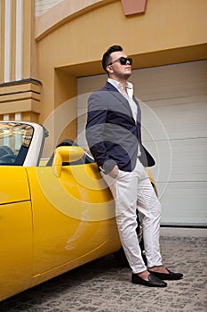 Man posing with convertible sportcar