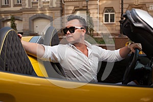 Man posing with convertible sportcar