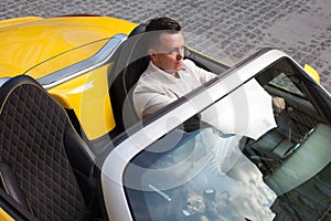 Man posing with convertible sportcar