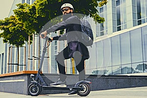 A man posing on electric scooter.