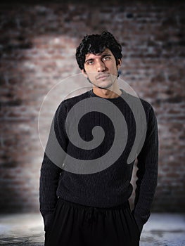 A Man Posing Heroically Against a Textured Brick Wall