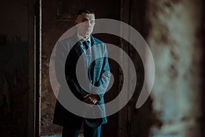 A man posing in the image of an English retro gangster in Peaky blinders style