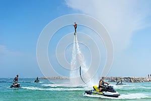 Man posing at new flyboard at Caribbean tropical beach. Positive