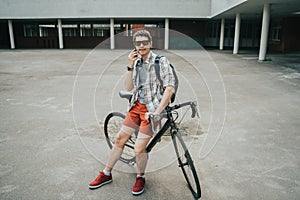 Man posing next to his bicycle.