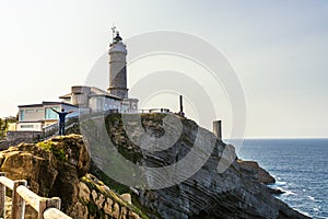 Man posing for a photo next to the lighthouse in Santander, Spain