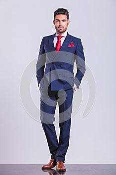 Man posing on studio background with hands in pockets