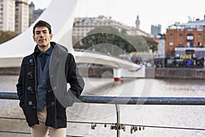 A man posing to camera near Puente de la Mujer (Woman\'s Bridge) in Puerto Madero, Buenos Aires photo