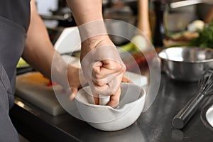 Man pounding spices in mortar during cooking classes