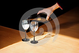 A man pouring champagne into a glass on some festive event or wedding reception