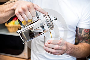 Man pouring coffee in cup