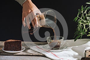 Man pouring cold brew coffee into glass on table