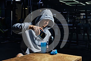 Man pouring energy sports supplement in bottle