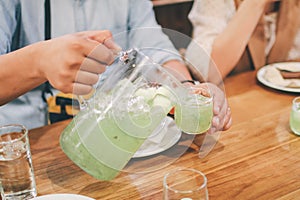 Man pouring fresh melon juices into glass  on wooden table.Delicious summer cold and refreshing drink.