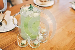 Man pouring fresh melon juices into glass  on wooden table.Delicious summer cold and refreshing drink.