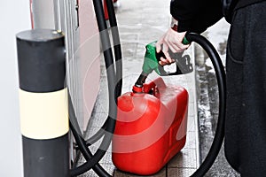 A man pouring fuel into a canister at a gas station