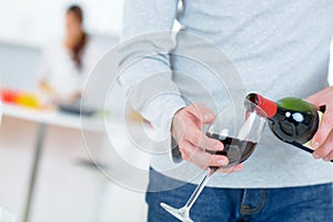 Man pouring himself glass red wine