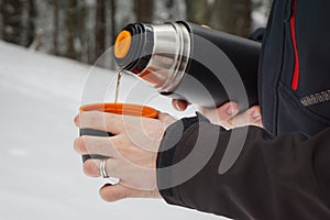 Man pouring hot tea from a vacuum flask