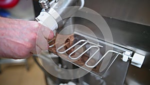 man pouring ice cream after pasteurization into the freezer, ice cream manufacture concept